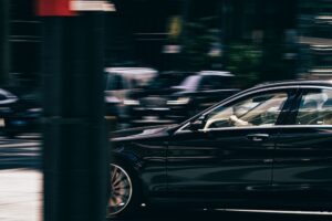 Black Lyft car moving down busy street in city about to have an accident