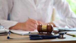 Court gavel with stethoscope on a table representing the concept of Medical Malpractice