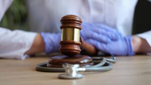 Close-up of female hands in gloves striking with judge hammer ilustrating the concept of Personal Injury Lawyer